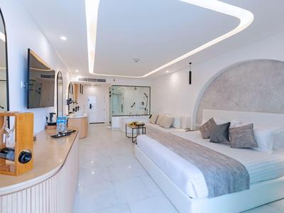 Modern eingerichtetes Hotelzimmer mit großem Bett, Sitzbereich und hellem Design.