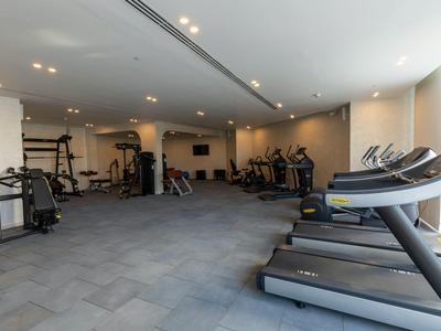 Ein moderner Fitnessraum mit Laufbändern und verschiedenen Trainingsgeräten in einem Hotel.