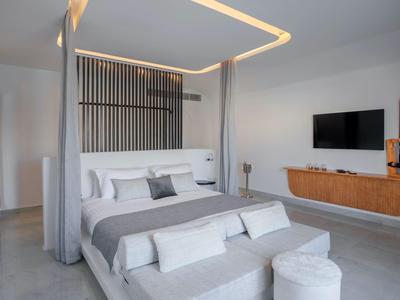 Modernes Hotelzimmer mit Doppelbett, TV und schlichter Dekoration in neutralen Farben.