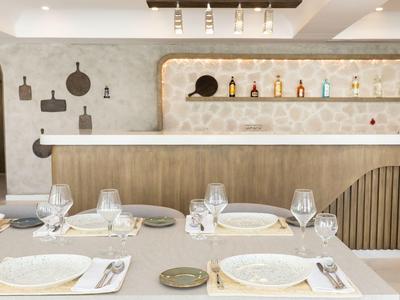 Area pranzo moderna con tavolo elegantemente apparecchiato e bar elegante sullo sfondo.