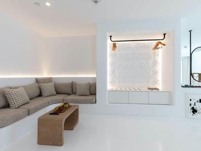 Area lounge moderna e luminosa in hotel con divano angolare grigio, tavolino in legno e decorazioni minimaliste.