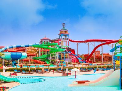 Gran parque acuático con toboganes coloridos y piscina azul bajo un cielo claro.