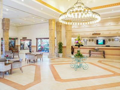 Heller, eleganter Hotellobbybereich mit großen Kronleuchtern und Sitzgelegenheiten.