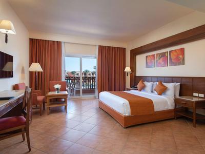Modernes Hotelzimmer mit Doppelbett, Schreibtisch und Balkon mit Aussicht.