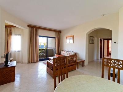 Salon lumineux avec coin repas, balcon et vue sur la mer dans un logement de vacances.