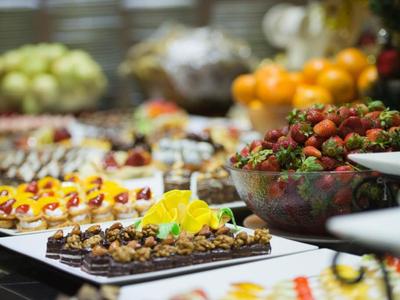 Buffet mit vielfältigen Desserts und Obst, darunter Erdbeeren und verschiedene kleine Kuchen.