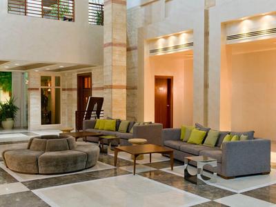 Moderne Hotellobby mit gemütlichen Sofas, Sesseln und großem Marmorboden in hellem Licht.