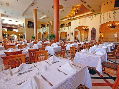Restaurant élégant avec des tables nappées de blanc et des tons chauds et terreux.