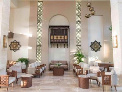 Heller Hotel-Loungebereich mit stilvollen Sitzmöbeln und orientalischer Dekoration.