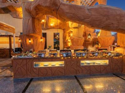 Buffetbereich mit warmem Licht und rustikaler, steinähnlicher Dekoration in einem Hotel.