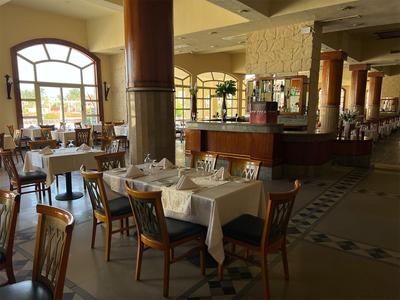 Hell beleuchteter Hotelrestaurantbereich mit elegant gedeckten Tischen und Holzmöbeln.