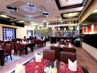 Eleganter Hotelrestaurantraum mit gedeckten Tischen und moderner Beleuchtung.