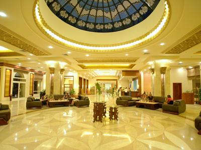 Großer Hotel-Lobby mit marmorgeflochtenem Boden und rundem, bemaltem Glasdach.