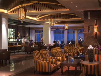 Gemütliche Hotel-Lounge mit gestreiften Sesseln und warmem Licht bei Abenddämmerung.