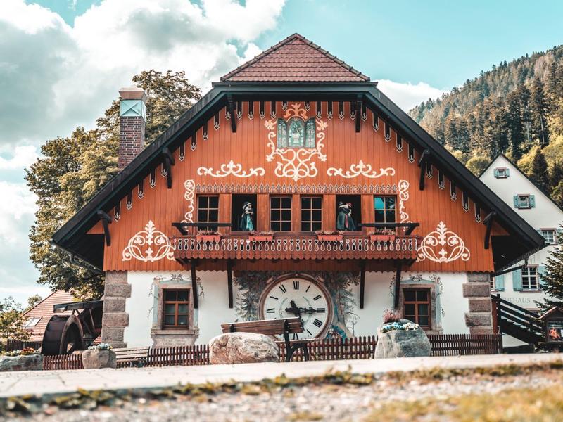 Traditionelles Chalet-Hotel mit großem Uhrzifferblatt und dekorativen Holzverzierungen