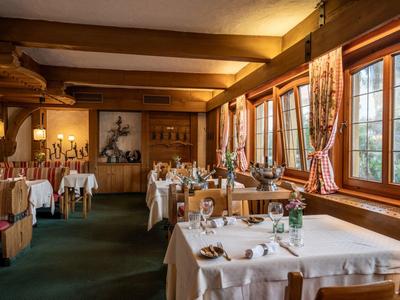 Gemütliches Restaurant mit großen Fenstern, weiß gedeckten Tischen und rustikalem Holzinterieur.