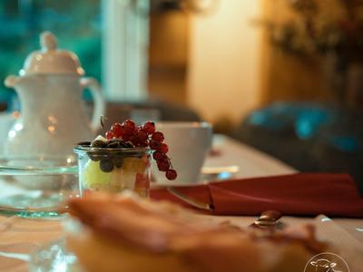 Ein gedeckter Frühstückstisch mit Obst, Tasse und Kaffeekanne in gemütlicher Umgebung.