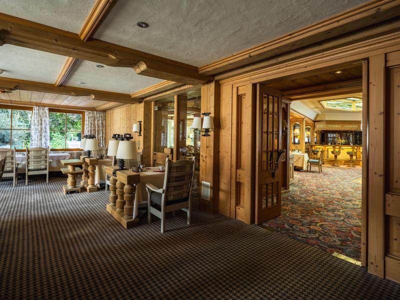 Gemütlicher Hotel-Loungebereich mit Holzvertäfelung, Teppichboden und großen Fenstern.