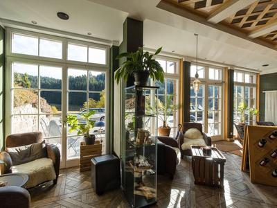 Wohnlicher Hotel-Loungebereich mit großen Fenstern und natürlichem Licht