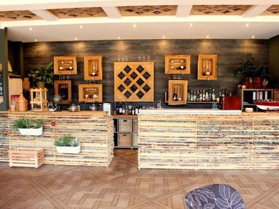 Rustikale Hotelbar mit Holztheke, dekorativen Weinkisten und Pflanzen arragements.