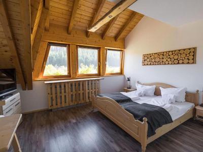 Gemütliches Hotelzimmer mit Holzmöbeln und großer Fensterfront mit Bergblick.