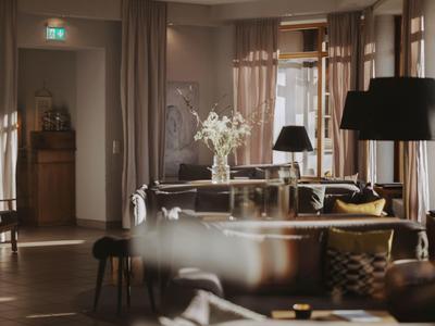 Eleganter Hotel-Lobbybereich mit Sofas, Blumen und sanfter Beleuchtung.