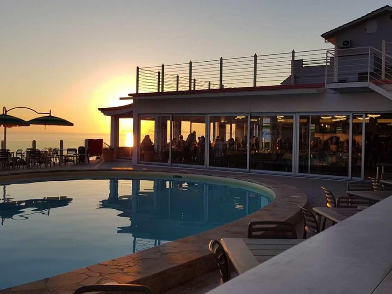 Strefa basenu hotelowego o zachodzie słońca z leżakami i parasolami