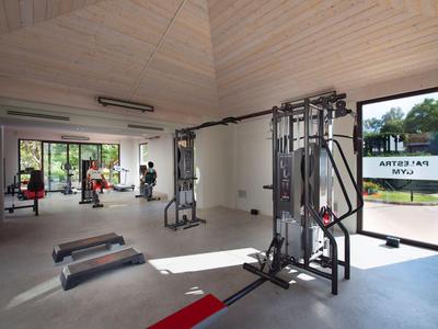 Moderner Fitnessraum mit Kraftmaschinen und großen Fenstern in einem Hotel.