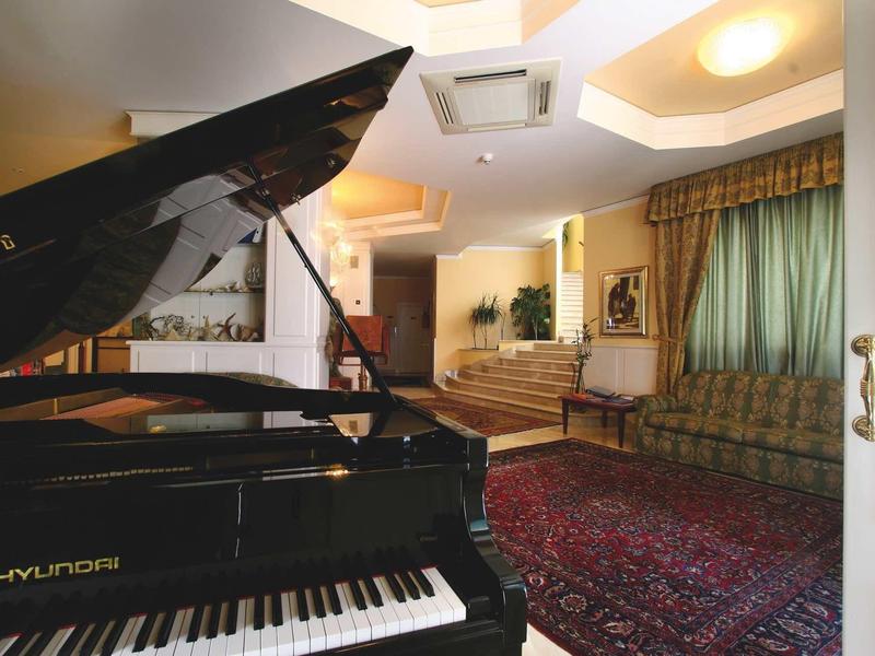 Przytulny salon z czarnym fortepianem, dywanem i miejscami do siedzenia w świetle dziennym.