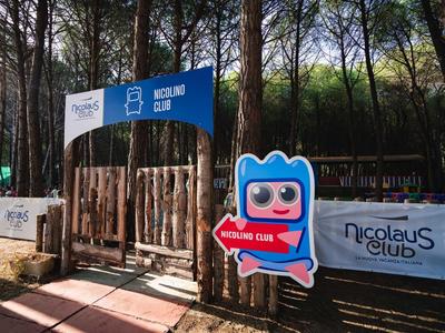 Entrance to a wooded leisure or holiday club area with colorful mascot sign.