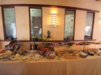 Buffet avec divers plats et boissons dans un restaurant à l'éclairage chaleureux.