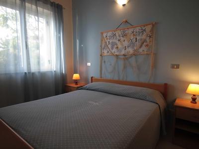 Chambre confortable avec lit double, lampes de chevet et suspension murale au crochet.