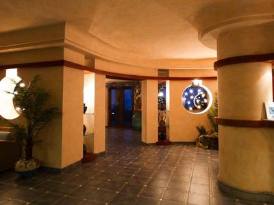 Hall d'hôtel lumineux avec coin salon et réception sous un éclairage chaleureux.