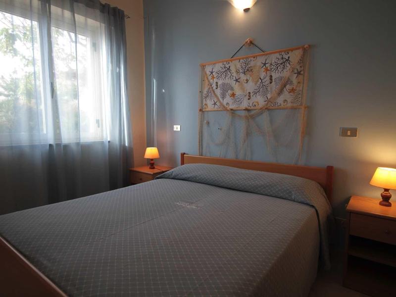 Chambre confortable avec lit double, lampes de chevet et suspension murale au crochet.