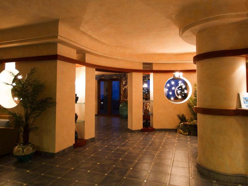 Hall d'hôtel lumineux avec coin salon et réception sous un éclairage chaleureux.