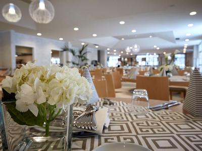 Modern dining room with white flower decoration and geometric carpet.