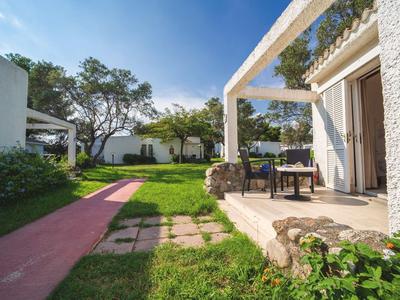 Taras hotelowy z miejscem do siedzenia i ścieżką ogrodową w słoneczny dzień