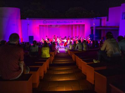Scène en plein air la nuit avec public et éclairage violet