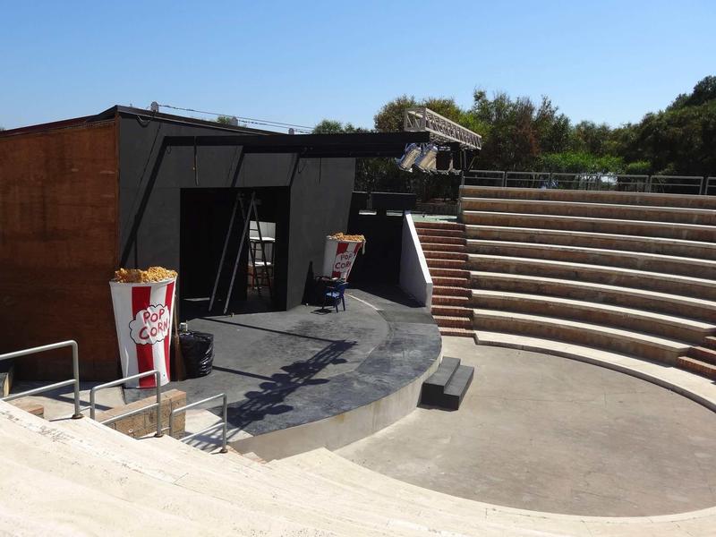 Open-air theater with stepped seating and black stage in a hotel park.