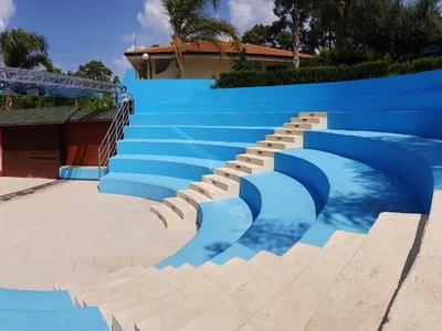 Leeres Amphitheater mit blauen und weißen Stufen im Außenbereich bei klarem Himmel