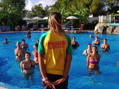 Eine Gruppe von Menschen im Pool bei einem Wasser-Aerobic-Kurs mit Trainerin.