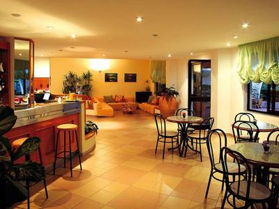 Gemütlicher Caféinnenraum mit Tischen, Stühlen, Tresen und warmer Beleuchtung.