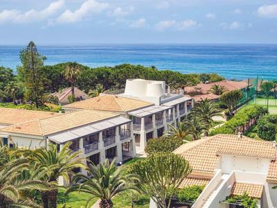 Kompleks hotelowy z zielonymi ogrodami, kortami tenisowymi i widokiem na morze