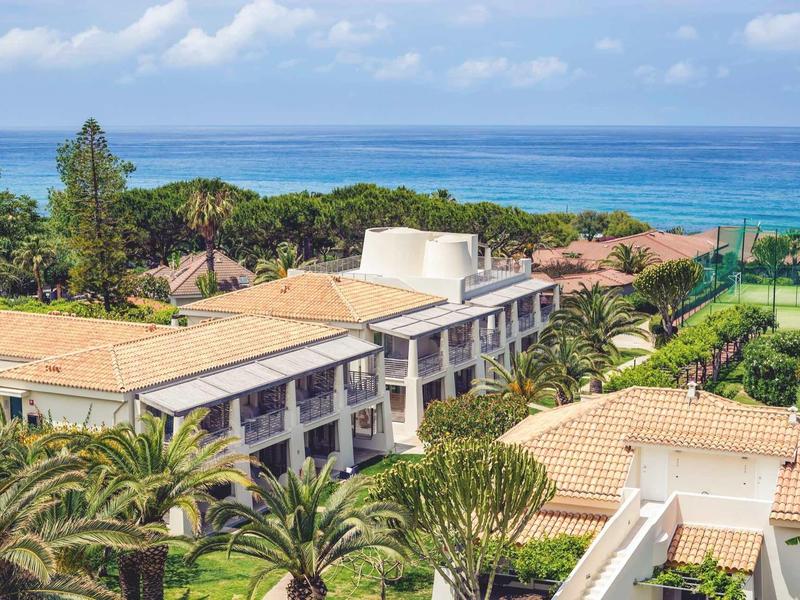 Kompleks hotelowy z zielonymi ogrodami, kortami tenisowymi i widokiem na morze