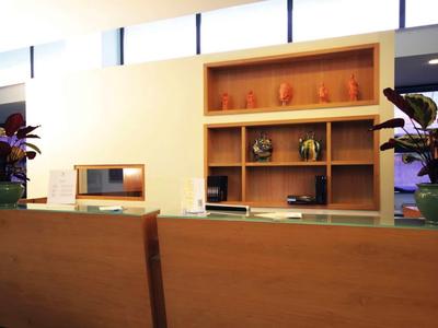 Modernly furnished hotel lobby area with wooden furniture and plants.