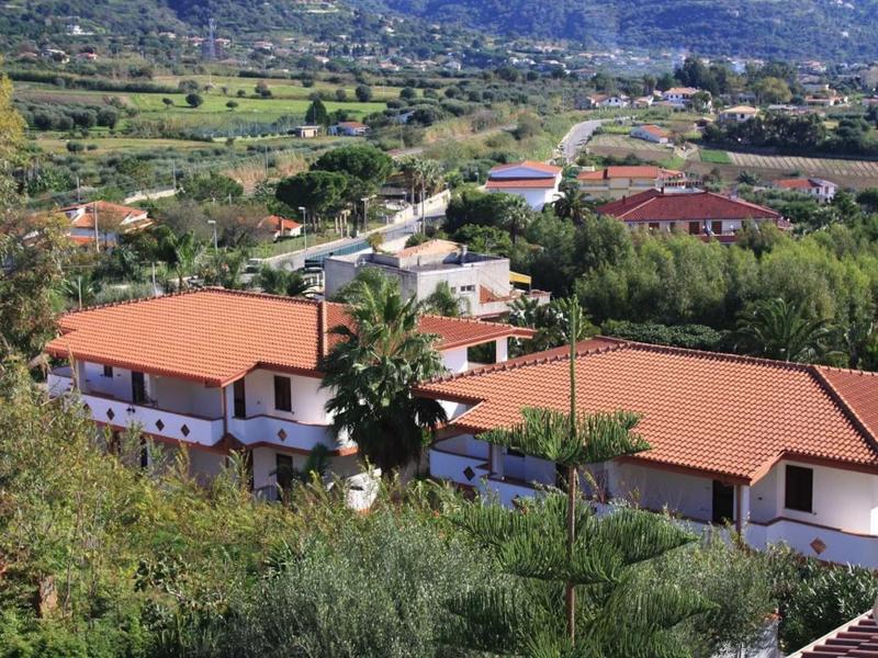 Hotel con tetti arancioni in paesaggio collinare con molta vegetazione