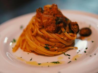 Spaghetti mit Tomatensauce und Kräutern, serviert auf einem weißen Teller.