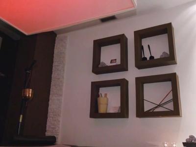 Čtyři dekorativní čtvercové rámy na bílé zdi v moderním interiéru.