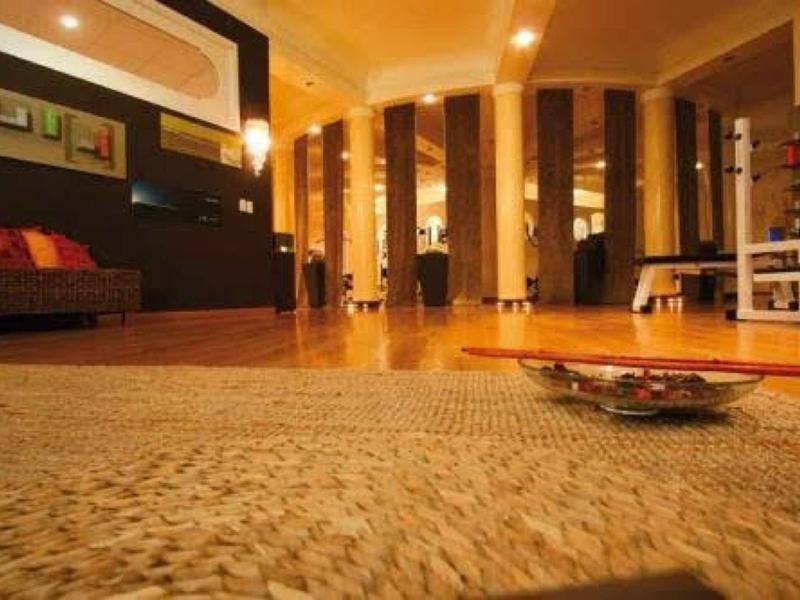 Pohodlný obývací pokoj s teplým osvětlením, čalouněným nábytkem a kobercem.