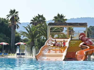 Scivoli d'acqua e piscina con palme sullo sfondo in un resort per vacanze.